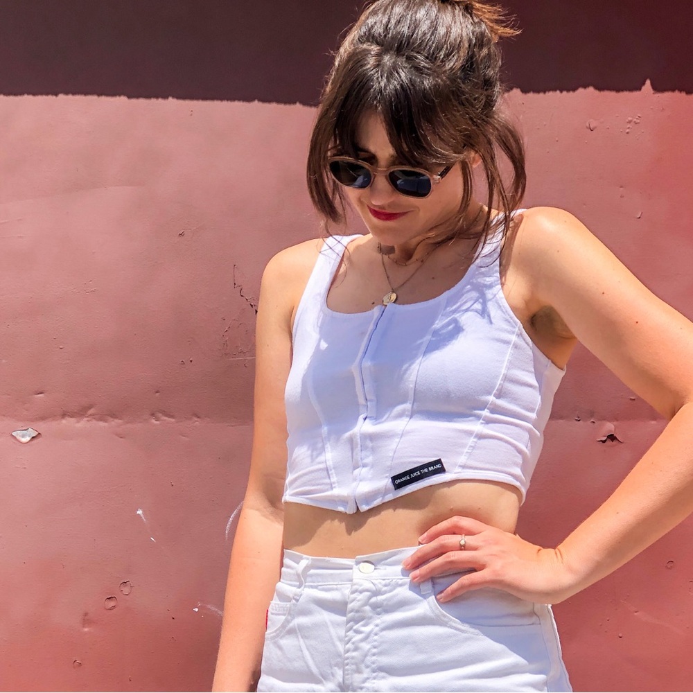 White corset top with clasps in the front, can be worn as a crop top or corset